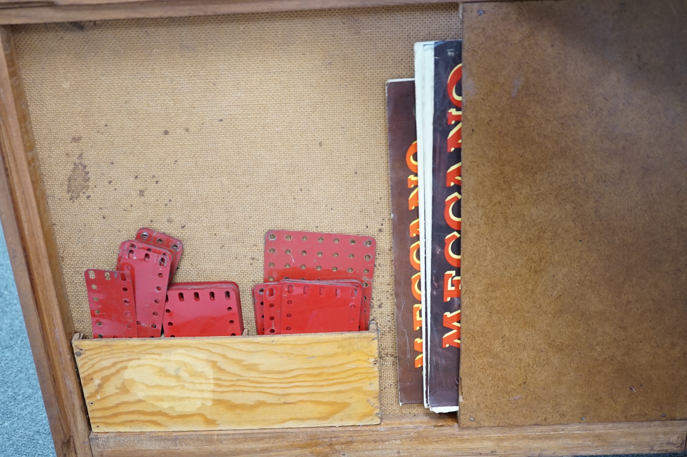 A collection of early Meccano components, mainly from the red and green period, comprising of some of the more unusual wheels and circular parts, some instruction books, etc. well organised into two wooden boxes